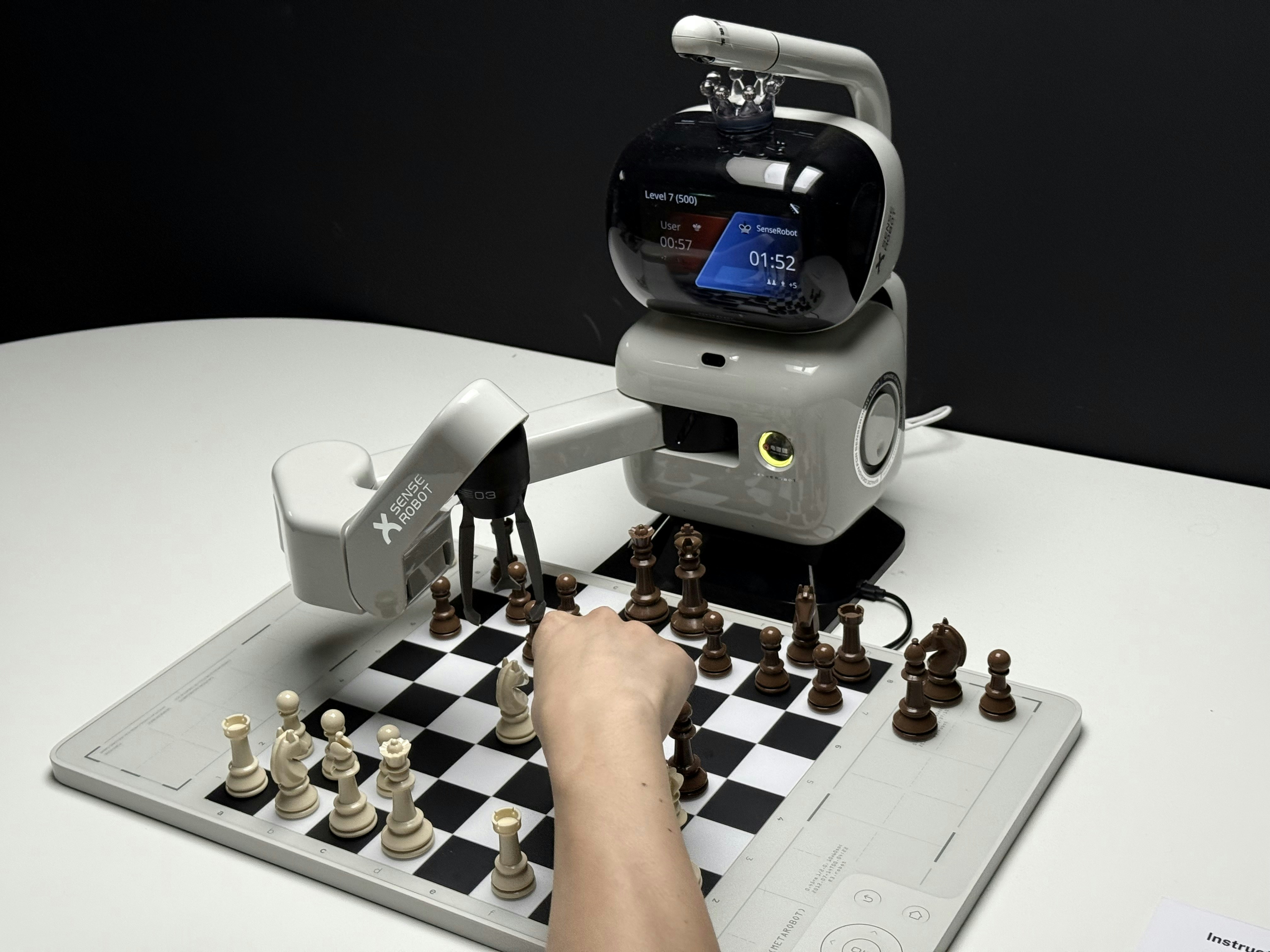 Robot arm playing chess with a human hand