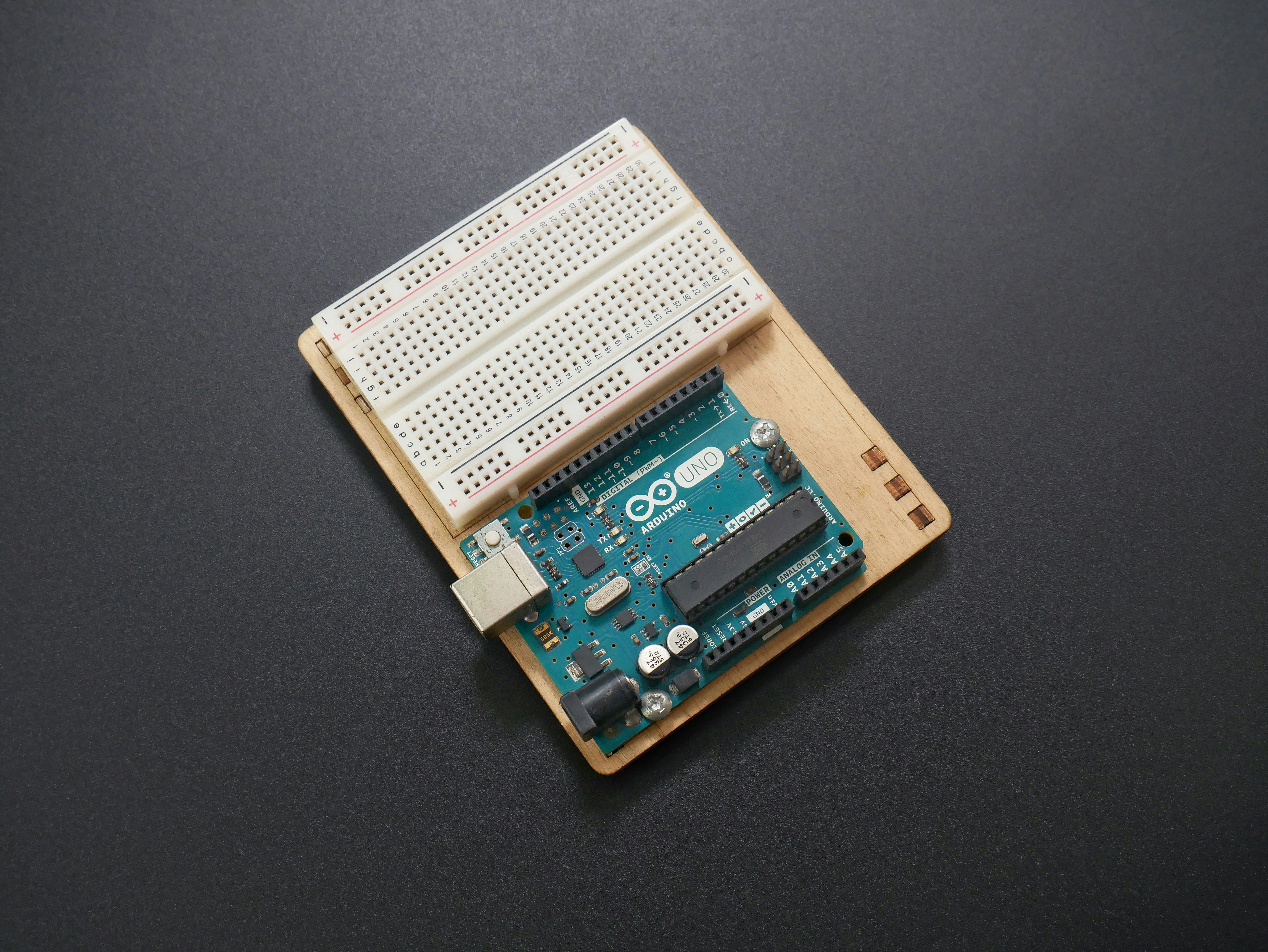 An Arduino Uno board along with a small breadboard. by Robotic Coding a close up of an electronic device on a table