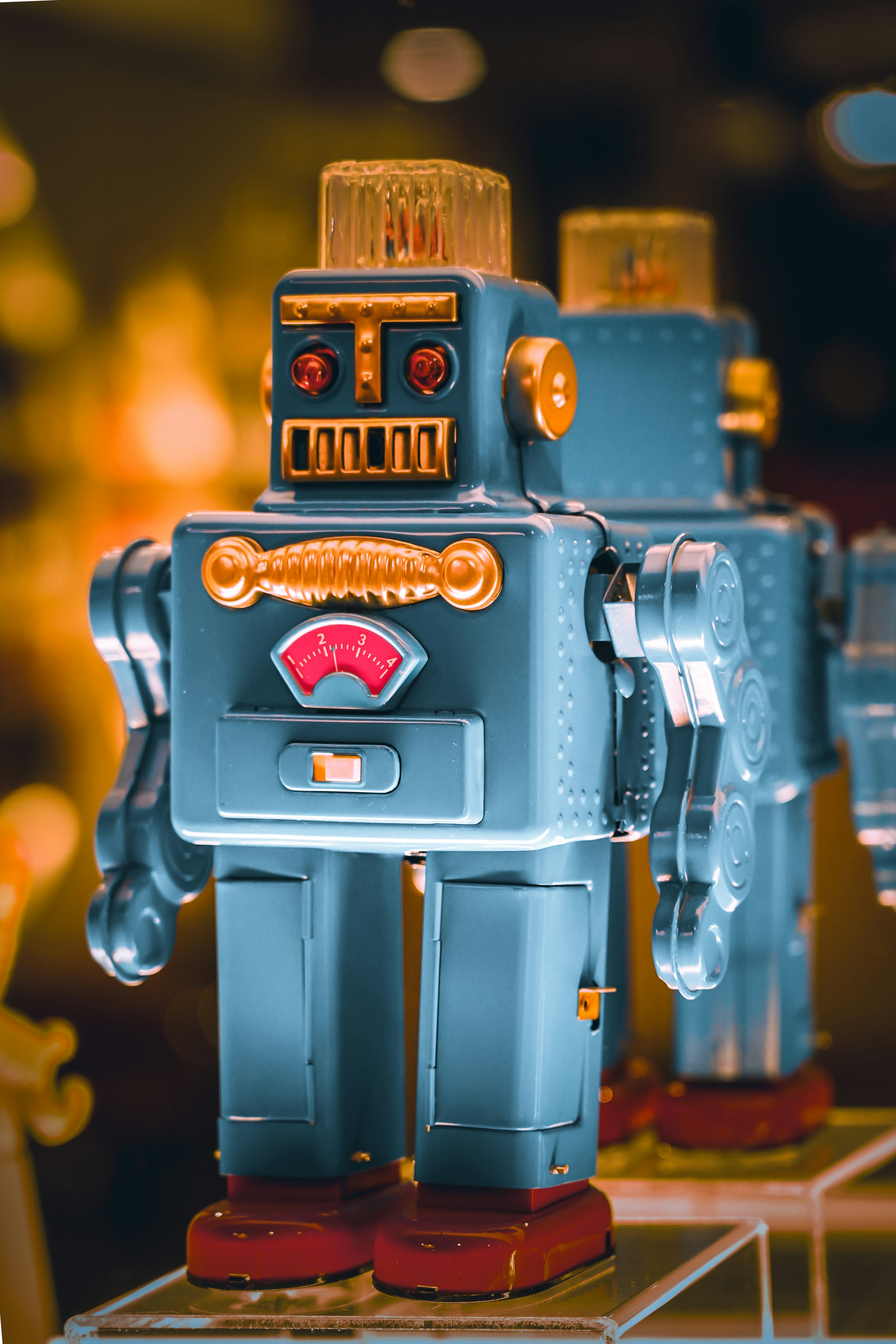 Two vintage tin robots standing side by side.