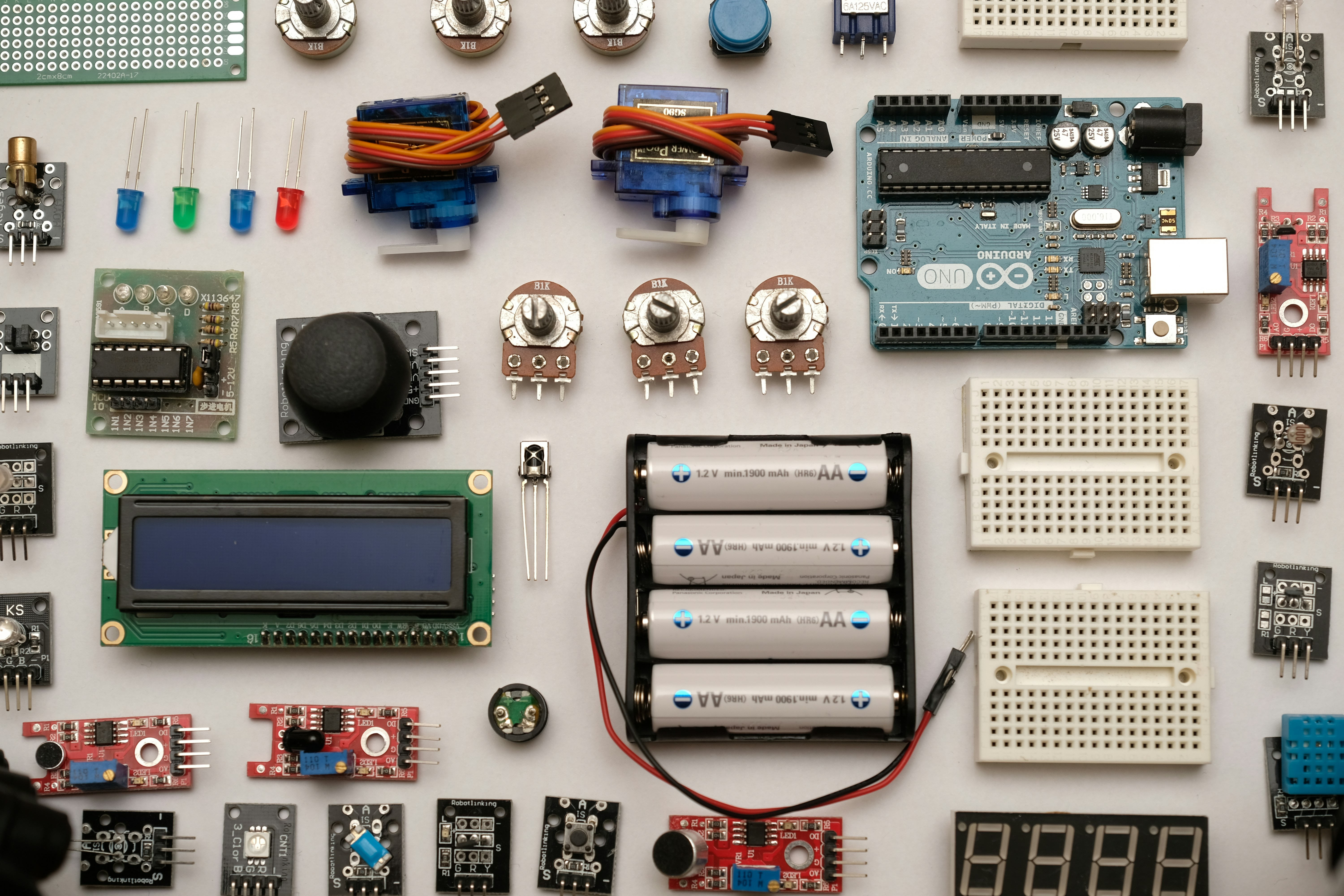 How do I connect and program sensors with Arduino for robotics applications? by Robotic Coding flat lay photography of circuit board