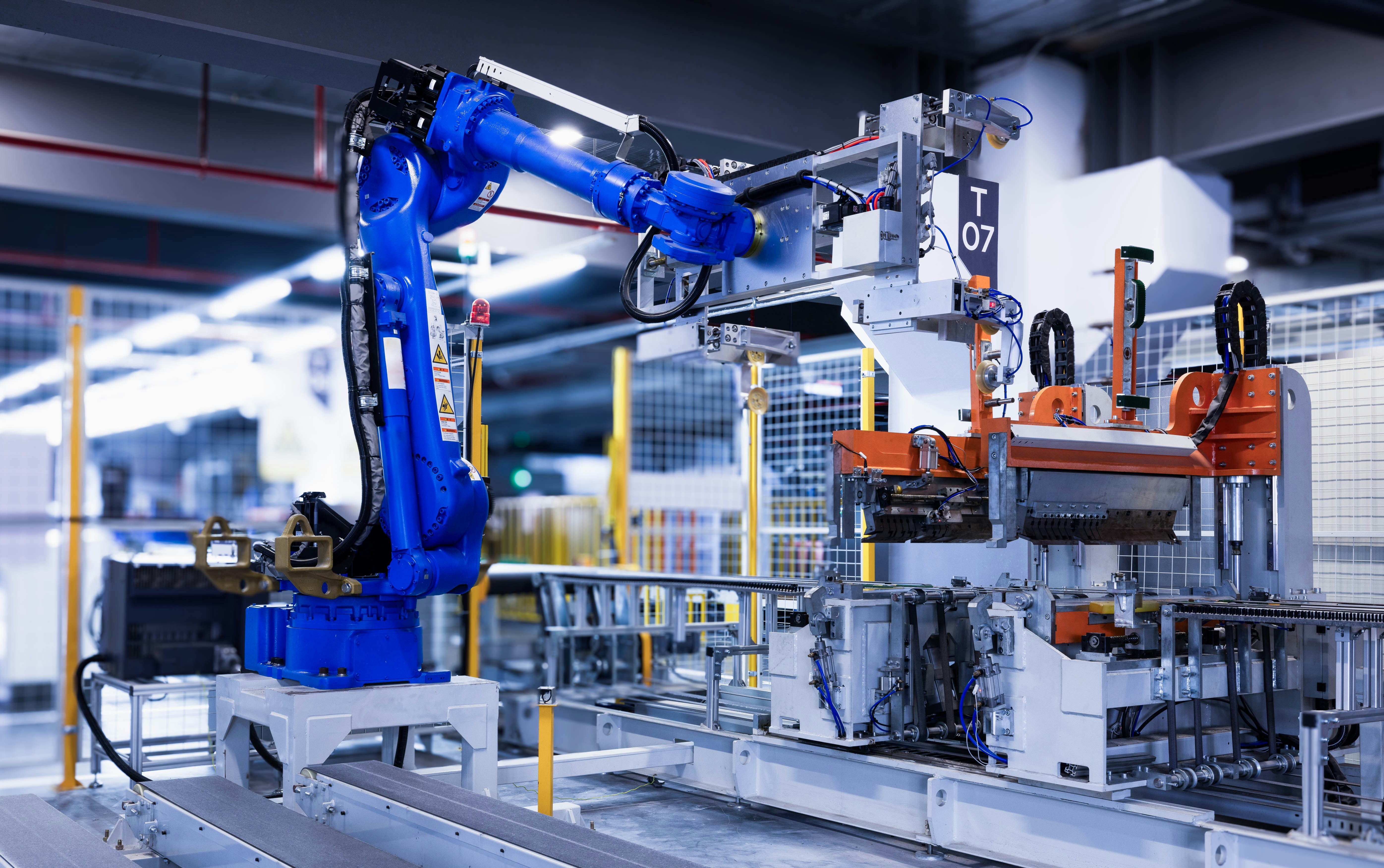 Close-up of the blue robot arm transporting a molded refrigeratorexterior laminate. by Robotic Coding blue industrial robot arm in factory