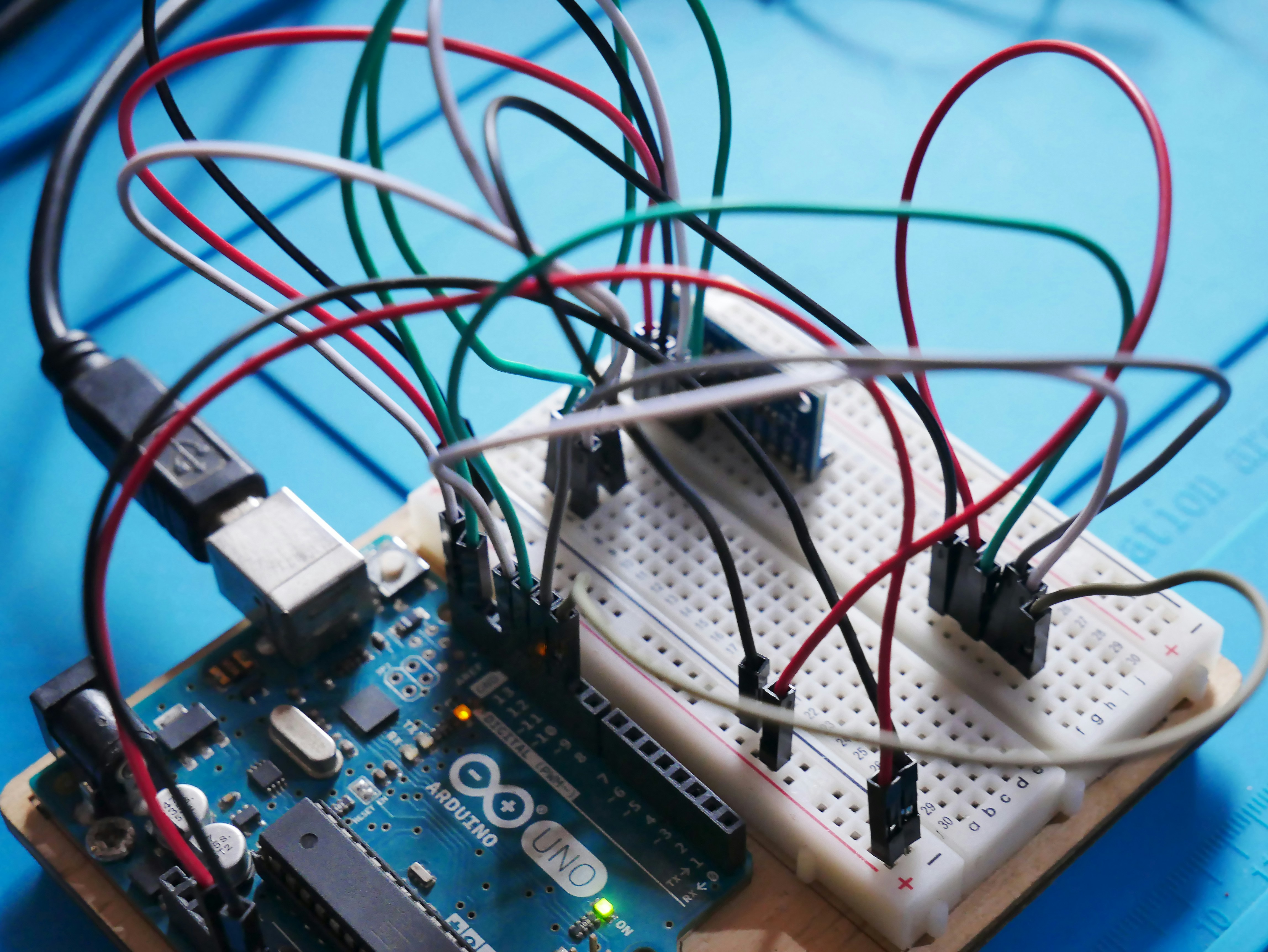 An Arduino Uno board wired to a couple of sensors on a breadboard. by Robotic Coding a close up of a board with wires attached to it